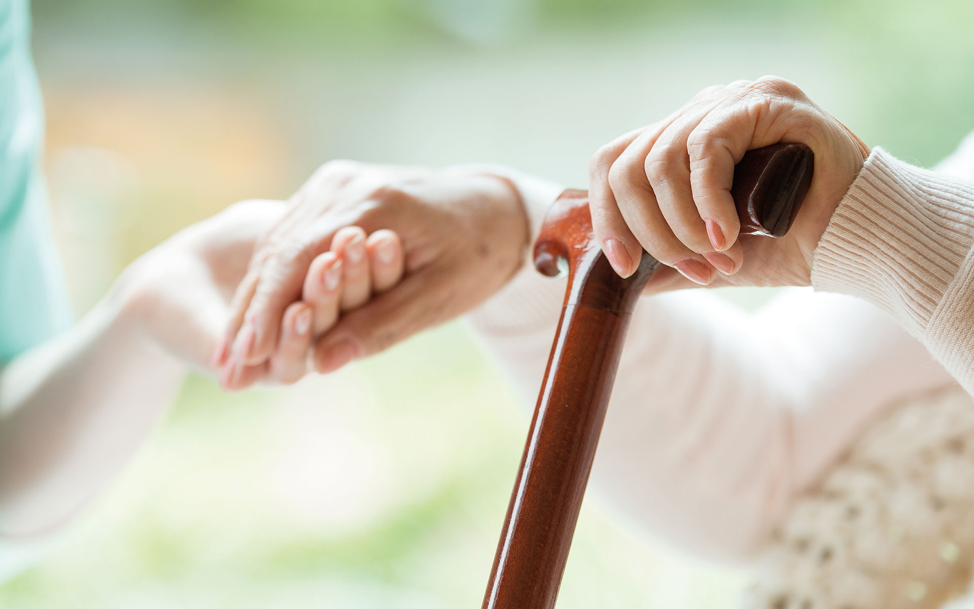 PflegePiloten, Weinstadt: Rentnerhände auf Gehtstock, gestützt von Pflegekraft